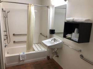 a bathroom with a sink and a shower and a bath tub at Inn Of Long Beach in Long Beach
