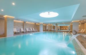 a large swimming pool in a hotel lobby at Boyalik Beach Hotel & Spa Cesme in Çeşme