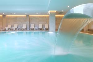 a swimming pool with a fountain in a hotel room at Boyalik Beach Hotel & Spa Cesme in Çeşme