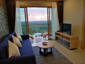 a living room with a blue couch and a television at Khaolak Blue Sky Villa in Khao Lak