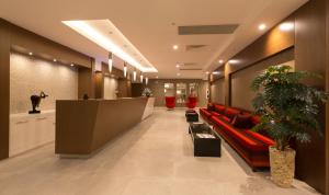 a lobby with a red couch in the middle at Boyalik Beach Hotel & Spa Cesme in Çeşme