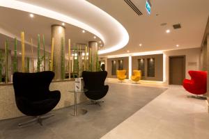a lobby with chairs and plants in a building at Boyalik Beach Hotel & Spa Cesme in Çeşme