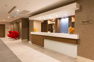a lobby with a reception counter and a red chair at Boyalik Beach Hotel & Spa Cesme in Çeşme