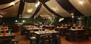 a restaurant with wooden tables and a large tent at Borobudur Bed & Breakfast in Borobudur