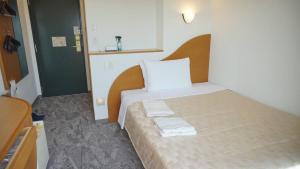 Postel nebo postele na pokoji v ubytování Naha Beach Side Hotel