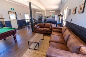 a living room with couches and a pool table at Oasis Newman in Newman