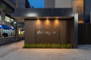 a building with a sign on the side of it at Dormy Inn Kawasaki Natural Hot Spring in Kawasaki
