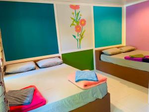 two beds in a room with colorful walls at Boon Nam Fah Resort in Chao Lao Beach +204 photos
