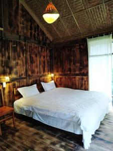 1 dormitorio con 1 cama blanca en una pared de madera en Anh Duc Homestay, en Sa Pa