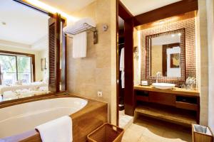 a bathroom with a tub and a sink and a mirror at Pullman Sanya Yalong Bay Villas & Resort in Sanya