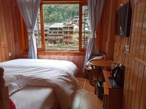 a bedroom with a bed and a large window at Fenghuang Memory Linjiang Inn in Fenghuang County