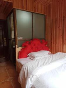 a bedroom with a large bed with a large red headboard at Fenghuang Memory Linjiang Inn in Fenghuang County