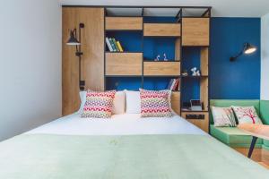 a bedroom with a large bed and a blue wall at Campanile Shanghai Huaihai in Shanghai