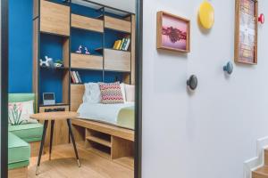 a bedroom with a bed and a desk and a table at Campanile Shanghai Huaihai in Shanghai