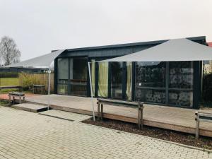 a building with a white tent in front of it at Fly in fly out in Mārupe