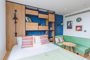 a bedroom with a bed and a desk and a table at Campanile Shanghai Huaihai in Shanghai