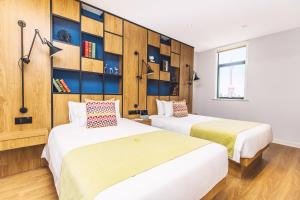 two beds in a room with wooden walls at Campanile Shanghai Huaihai in Shanghai