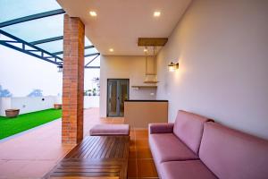 un soggiorno con un divano e un tavolo di Nova Highlands Hotel a Cameron Highlands