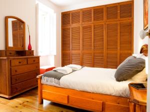 リスボンにあるMyplace - Lisbon Castleのベッドルーム1室(大きな木製ヘッドボード付きのベッド1台付)