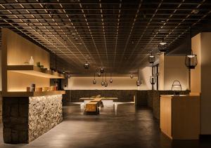 a large room with a table and a stone wall at ORIENTAL HOTEL KYOTO ROKUJO in Kyoto