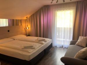 a bedroom with two beds and a couch and a window at Townville Chalet´s in Flachau