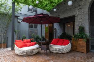 two chairs and an umbrella on a patio at Campanile Shanghai Huaihai in Shanghai