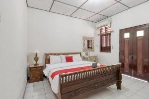 - une chambre avec un grand lit et un banc en bois dans l'établissement RedDoorz Syariah near Wijilan 2 Yogyakarta, à Yogyakarta