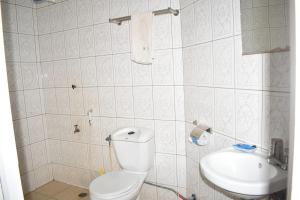 a bathroom with a toilet and a sink at Rainbow Executive Lodge in Boma la Ngombe