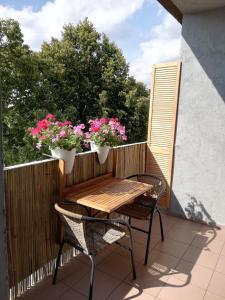 a wooden table and chairs on a balcony with flowers at Apartament Classic in Malbork