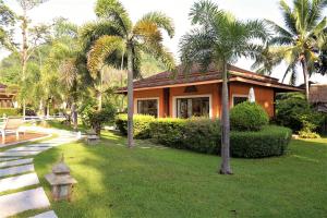 a house with palm trees in front of a yard at Laguna Villas Boutique Hotel in Ko Yao Noi