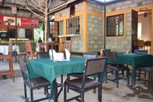 a dining room with two green tables and chairs at Rainbow Executive Lodge in Boma la Ngombe