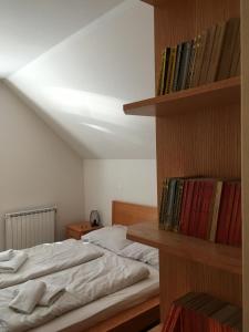a bedroom with a bed and a book shelf with books at Apartments Otašević in Kranjska Gora