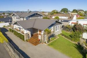 a large white house with a roof at Delightful on Devonport in Tauranga