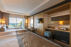 a hotel room with a bed and a view of the ocean at Boyalik Beach Hotel & Spa Cesme in Çeşme