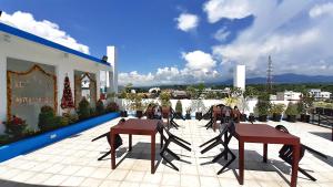 a patio with tables and chairs on a roof at Rosetta Guest House in Ormoc