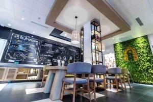 a restaurant with a bar with blue stools at Campanile Shanghai Huaihai in Shanghai