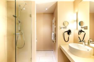 a bathroom with a shower and a sink at ACHAT Hotel Bremen City in Bremen