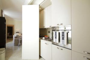 uma cozinha com armários brancos e um forno com placa de fogão em Crispi Luxury Apartments - My Extra Home em Roma
