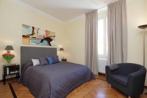ローマにあるクリスピ ラグジュアリー アパートメンツ マイ エキストラ ホームのベッドルーム1室(ベッド1台、椅子付)