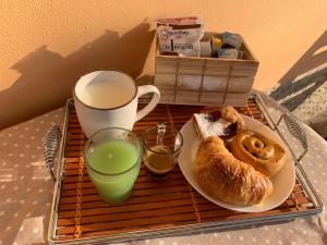 ein Tablett mit einem Teller Gebäck und einer Tasse Saft in der Unterkunft B&b A casa della nonna in Paestum