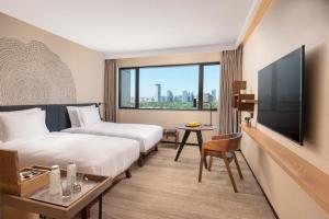 a hotel room with two beds and a large window at BEI Zhaolong Hotel, part of JdV by Hyatt in Beijing