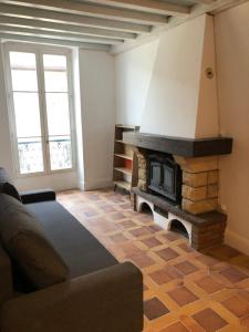 a living room with a stone fireplace in the corner at Immeuble de charme La Tronche in La Tronche