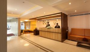 un vestíbulo con dos hombres sentados en un mostrador en Flora Charishma Residency Aluva, en Kochi