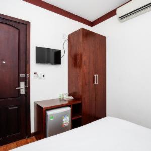 1 dormitorio con 1 cama, armario y TV en Brown Bean 2 Hotel, en Da Nang