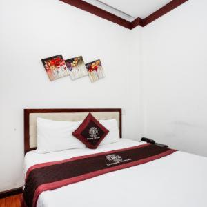 a bedroom with a bed with pictures on the wall at Brown Bean 2 Hotel in Danang