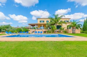 a villa with a swimming pool in front of a house at Can Bou in Ses Salines