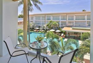 a balcony with a table and chairs and a building at Chi Samui Resort in Bophut