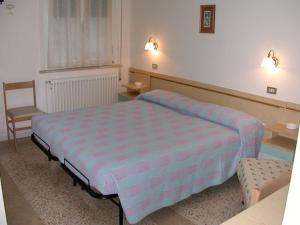 ein Schlafzimmer mit einem großen Bett und einem Stuhl in der Unterkunft Villa Linda Affittacamere in Bellaria-Igea Marina