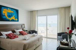 sypialnia z łóżkiem i widokiem na ocean w obiekcie Theo Sunset Bay Hotel w Pafos