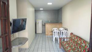 a room with a table and chairs and a television at Praia Apart Hotel in Natal